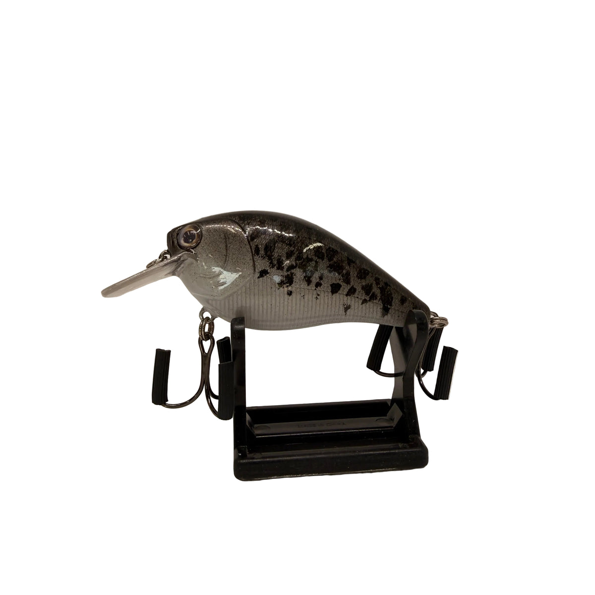 A hard fishing lure shaped like a fish, displayed on a black stand against a plain white studio background.