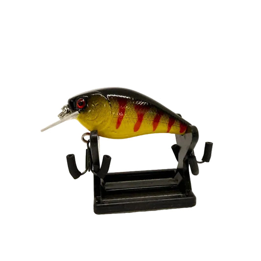 A hard bait fishing lure with a black, yellow, and red striped pattern, mounted on a black display stand against a white background.